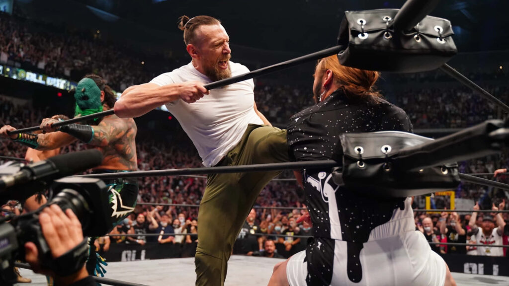 Bryan Danielson performing powerful knee strike AEW wrestling match vibrant crowd intense lighting Wallpaper