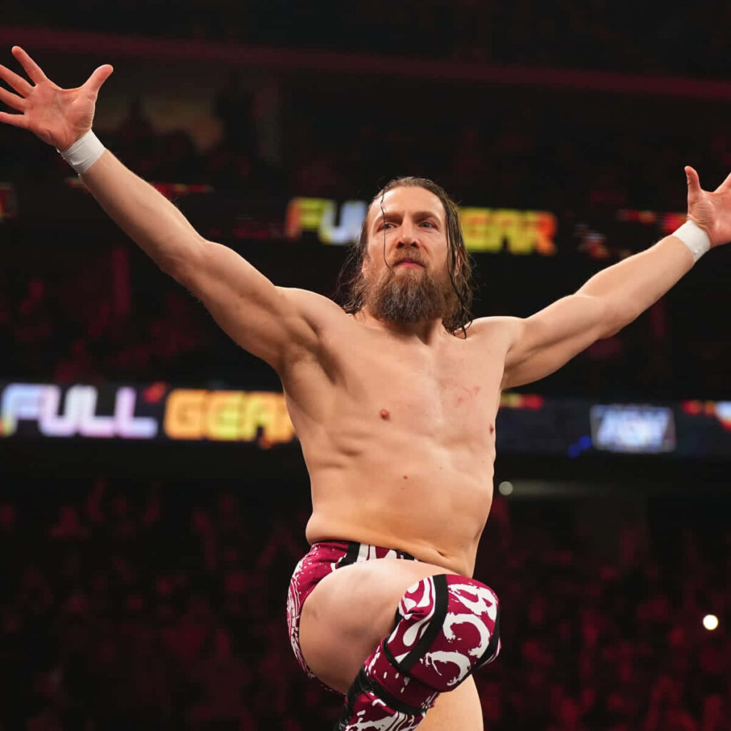 Bryan Danielson in bold red and white wrestling gear triumphant under vibrant arena lights wallpaper
