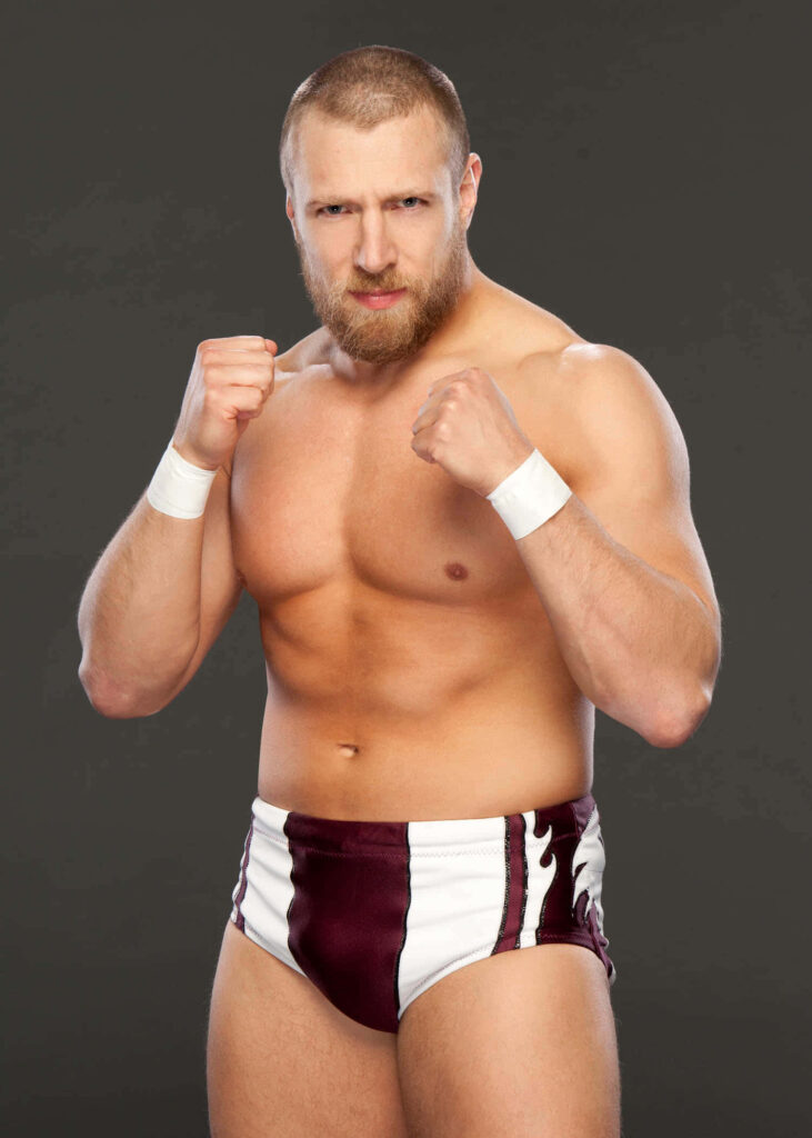 Bryan Danielson in maroon white wrestling trunks posing fiercely on dark background wallpaper