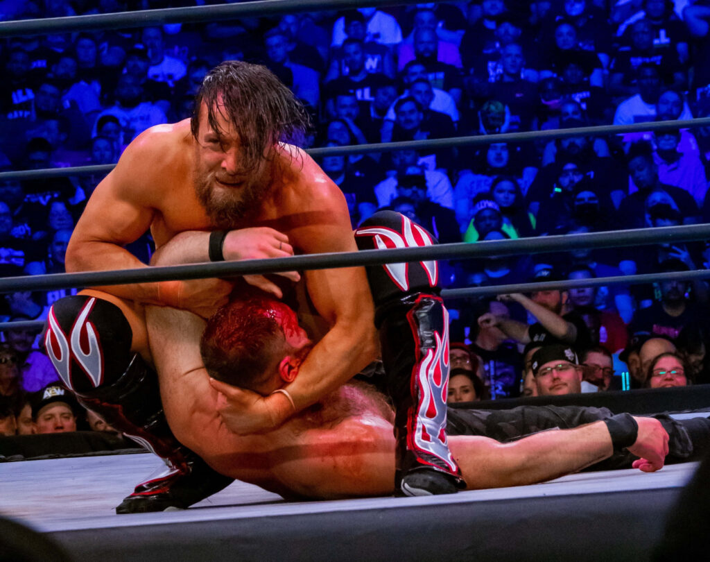 Bryan Danielson wrestling action wallpaper vibrant arena crowd intense athleticism background