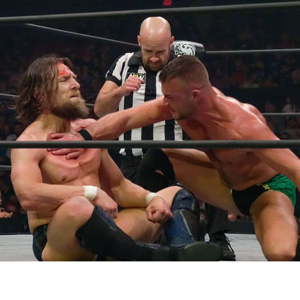 Bryan Danielson and Daniel Garcia intense wrestling action with dramatic lighting and dynamic poses Wallpaper