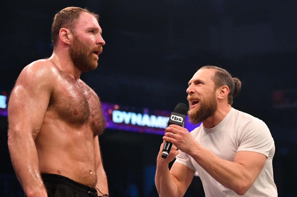 Bryan Danielson delivering intense promo to Jon Moxley in vibrant wrestling arena dynamic wallpaper