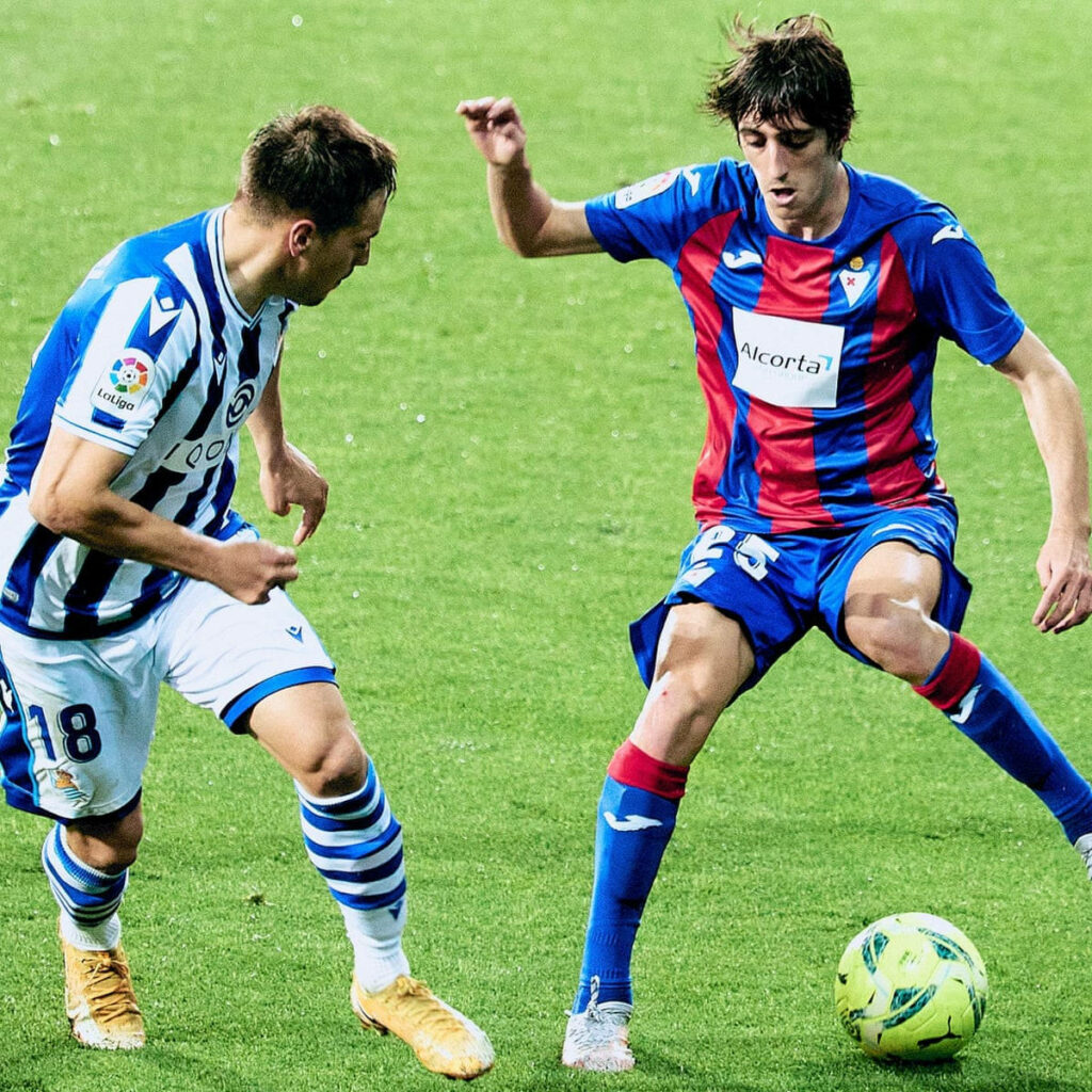 Bryan Gil defending the ball in Eibar kit during intense football match action high definition wallpaper
