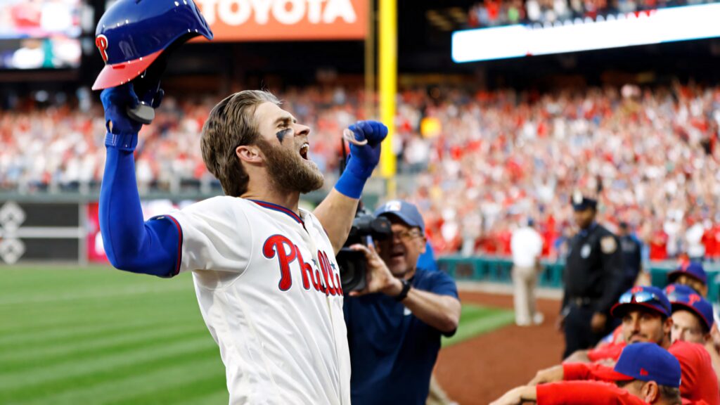 Bryce Harper celebrating in Phillies uniform with vibrant crowd background baseball fans wallpaper