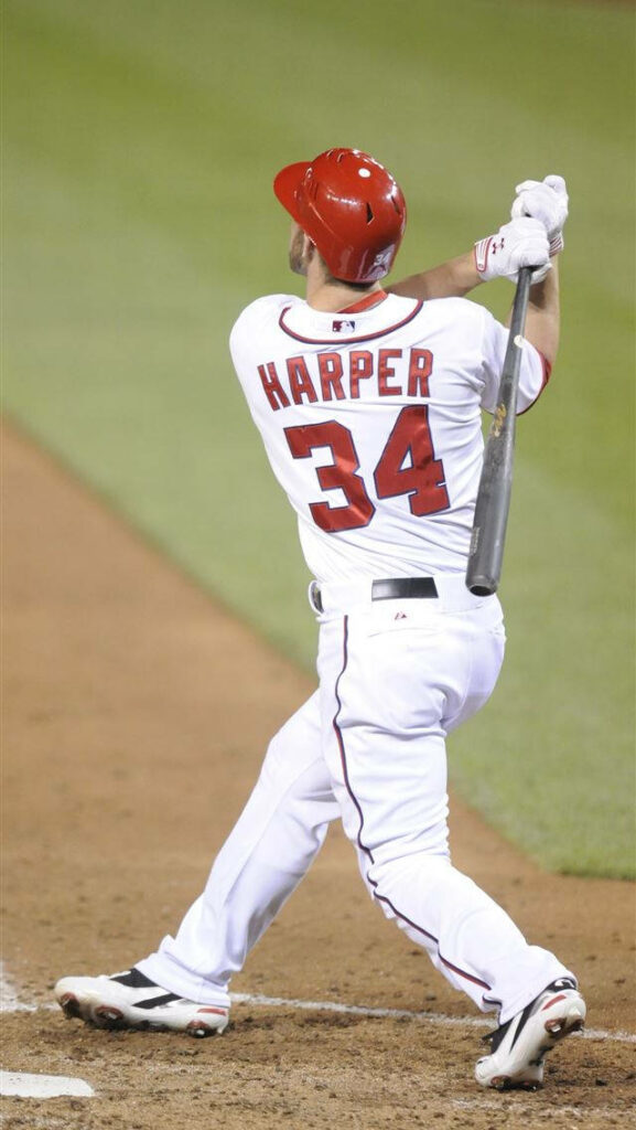 Bryce Harper powerful mid-swing baseball bat wallpaper in white red uniform number 34 MLB star