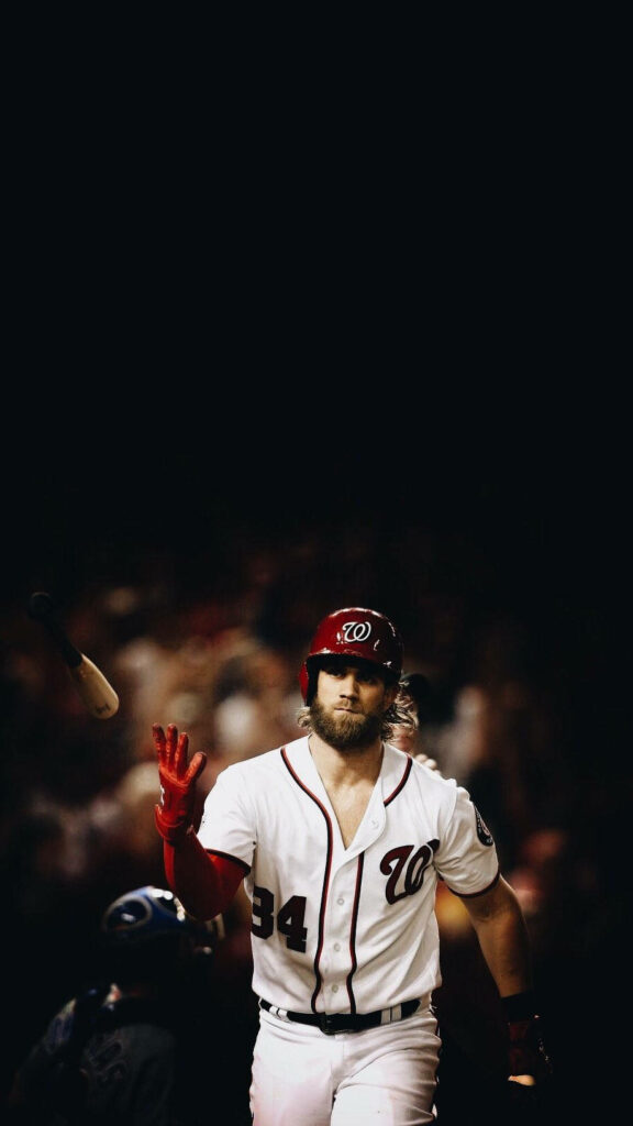 Bryce Harper mid-game in Nationals uniform number 34 with red cap and intense sports action wallpaper
