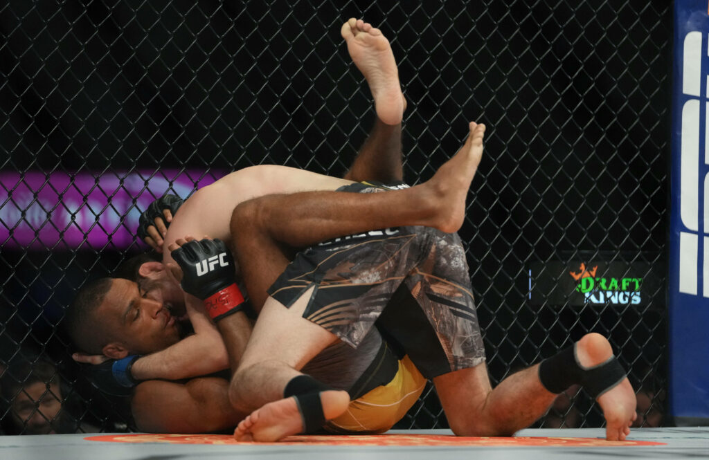 Bryce Mitchell pins Edson Barboza in UFC octagon showcasing grappling skill and intense MMA action Wallpaper