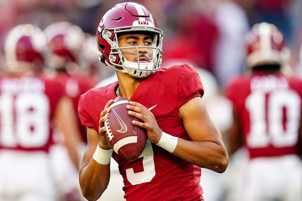 Bryce Young Alabama quarterback in crimson uniform ready to throw football vibrant stadium wallpaper