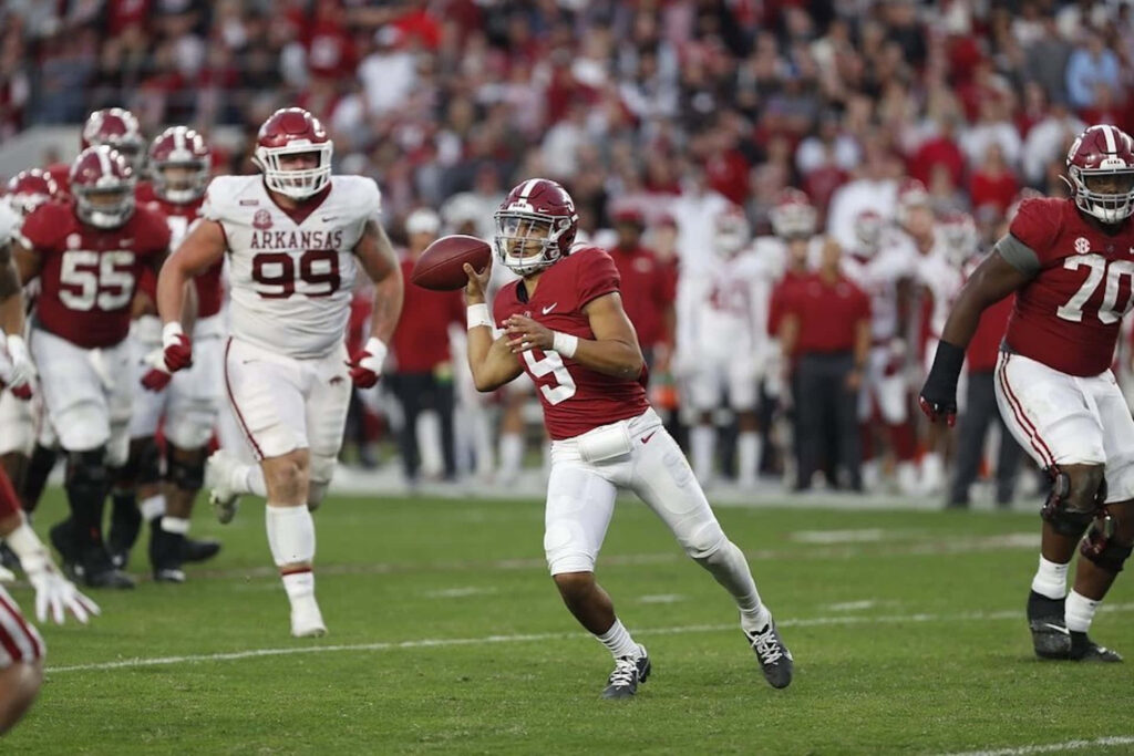Bryce Young Alabama quarterback evading defenders on field vibrant stadium football wallpaper