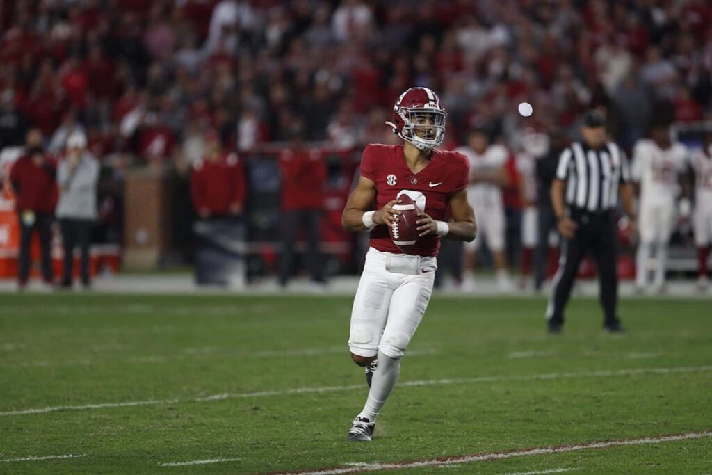 Bryce Young Alabama quarterback action shot poised to throw vibrant NCAA football stadium background Wallpaper
