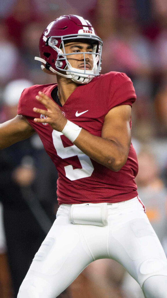 Bryce Young Alabama quarterback mid-throw in crimson jersey intense football action wallpaper