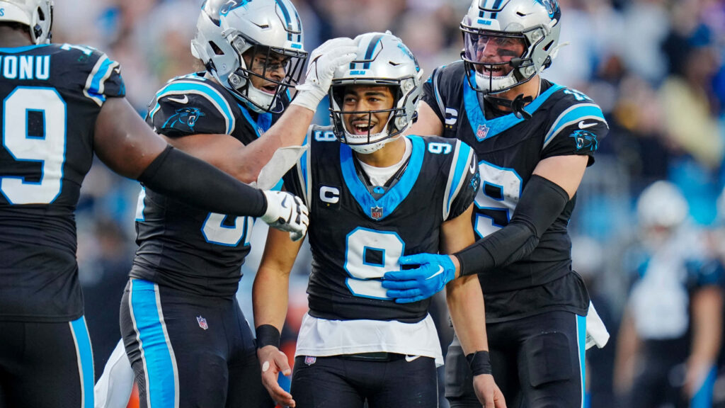 Bryce Young celebrating with Carolina Panthers teammates in black and blue uniform high-definition action Wallpaper
