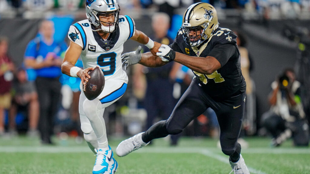 Bryce Young Panthers quarterback evades Saints defender dynamic NFL game action wallpaper