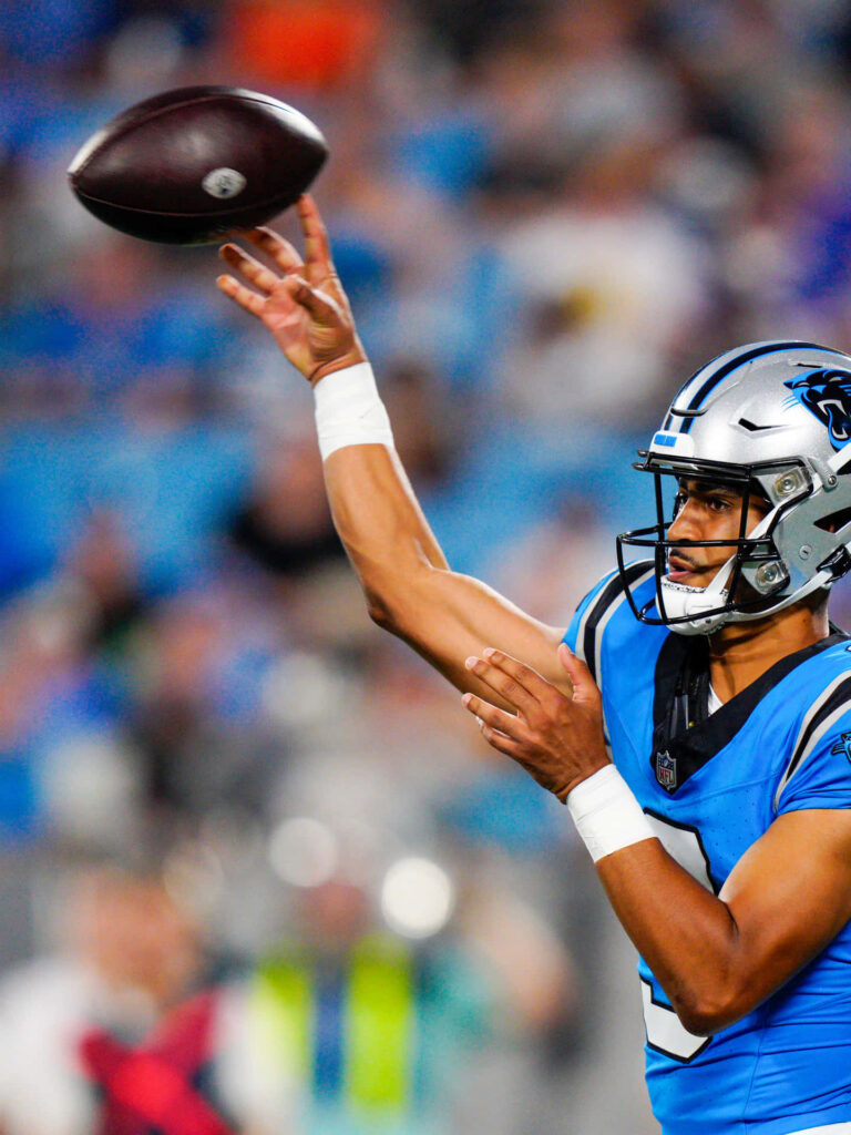 Bryce Young Carolina Panthers quarterback mid-throw in blue black uniform on football field wallpaper