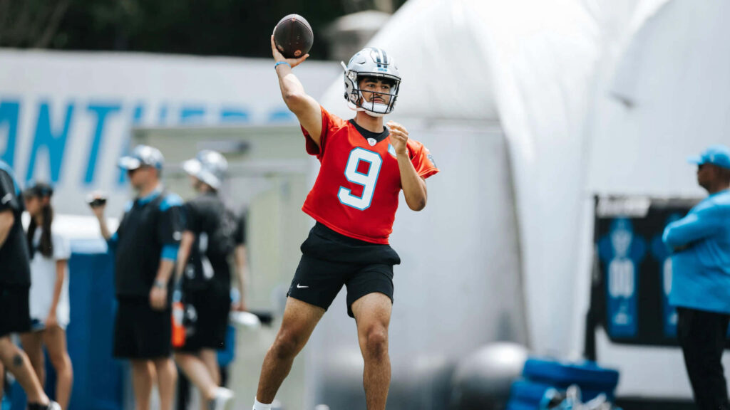 Bryce Young Carolina Panthers quarterback red jersey number 9 throwing football during practice Wallpaper