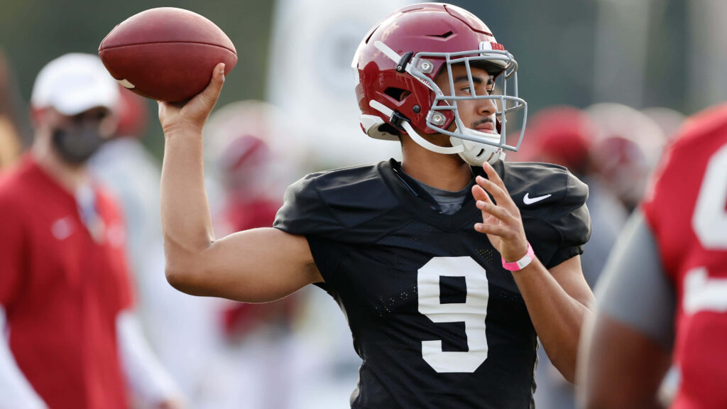 Bryce Young quarterback training session in crimson helmet black jersey number 9 throwing football Wallpaper
