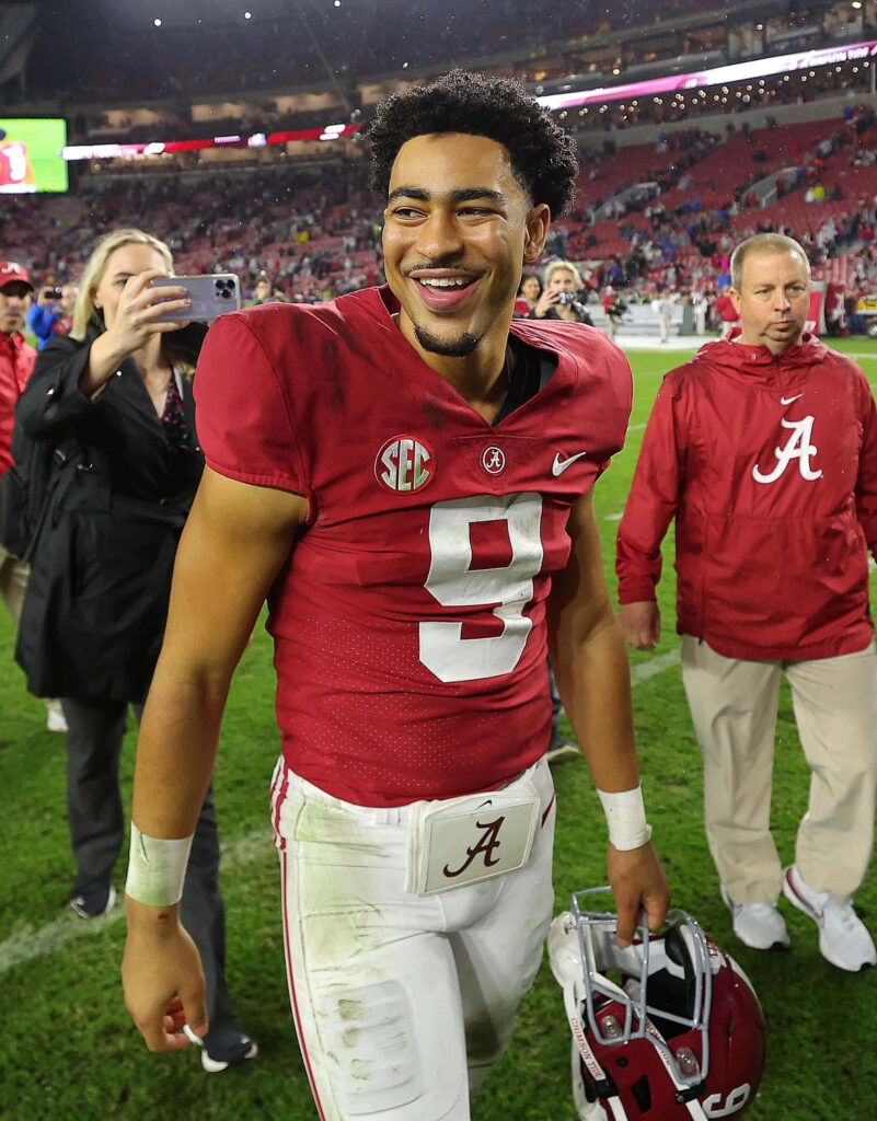 Bryce Young smiling post game in Alabama crimson jersey number 9 with vibrant stadium background Wallpaper