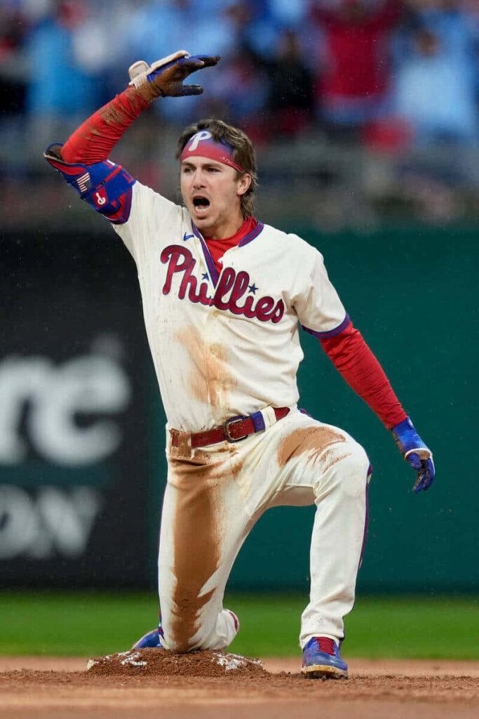 Bryson Stott Phillies baseball celebrating on infield dirt with dirt-stained uniform vibrant wallpaper