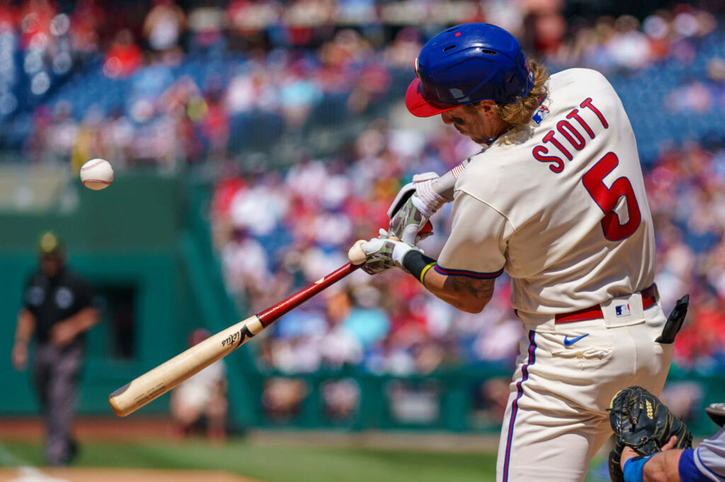 Bryson Stott Phillies mid-swing baseball action sharp focus vibrant stadium dynamic sports wallpaper