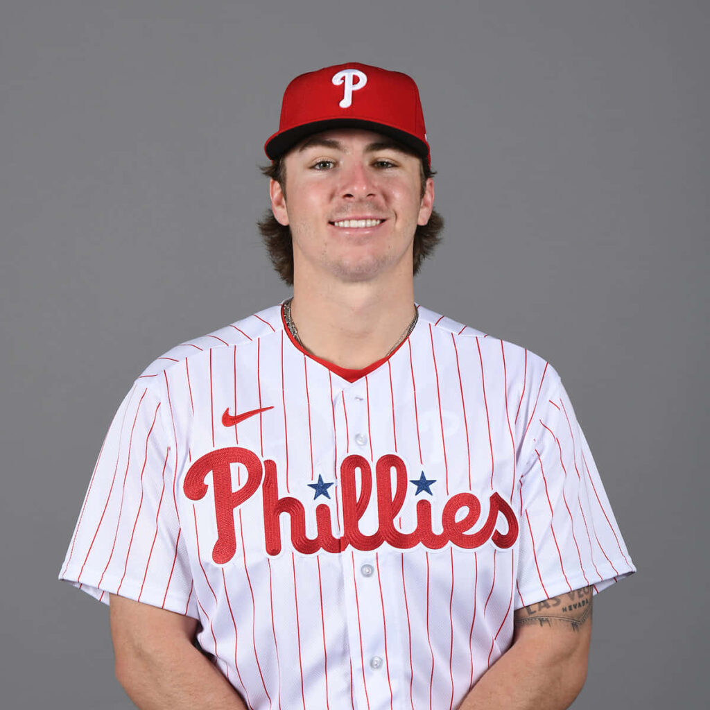 Bryson Stott Phillies portrait in white pinstriped uniform and red cap on gray background Wallpaper