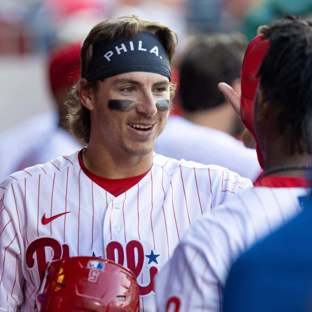 Bryson Stott Phillies infielder in white pinstripe uniform smiling in dugout baseball wallpaper background