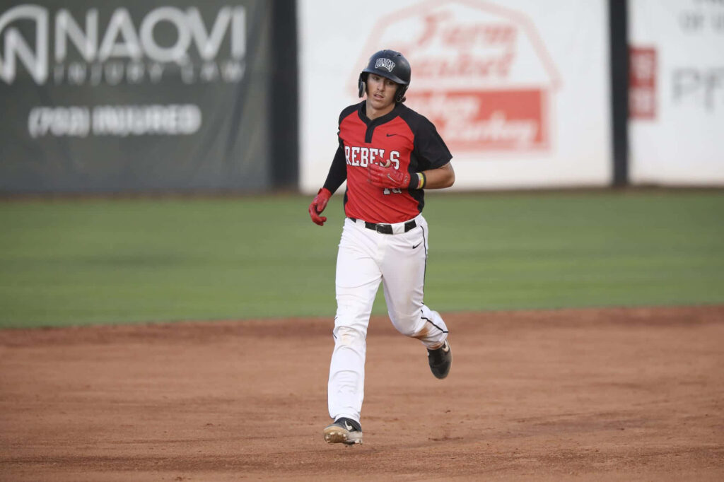 Bryson Stott running bases in vibrant Rebels uniform on sunlit baseball field action wallpaper