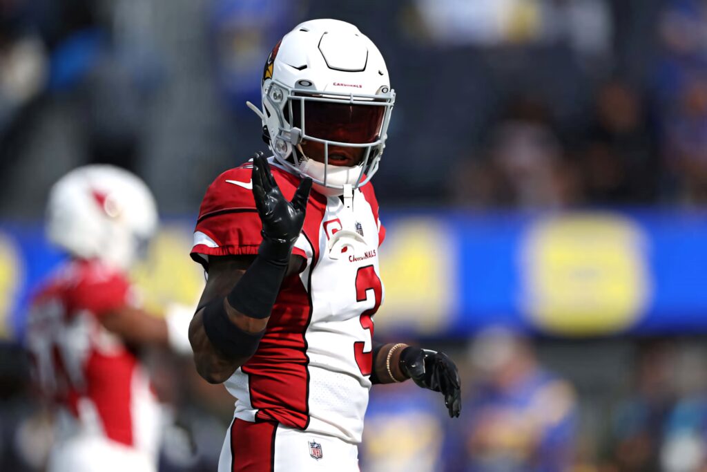 Budda Baker in Arizona Cardinals uniform number 3 on football field mid-game showing focus and strength Wallpaper