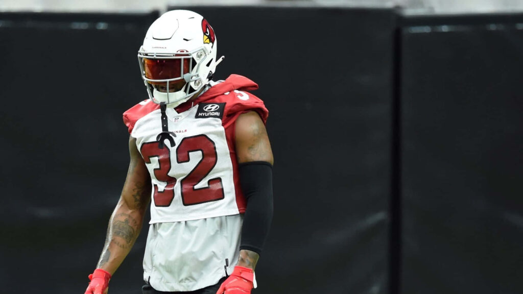 Budda Baker Arizona Cardinals in white helmet red jersey number 32 focused ready on football field Wallpaper