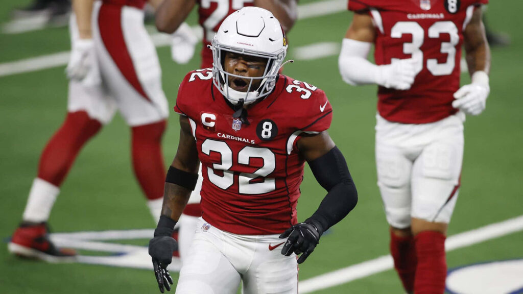Budda Baker Arizona Cardinals mid-action intense game play vibrant red white uniform stadium background Wallpaper