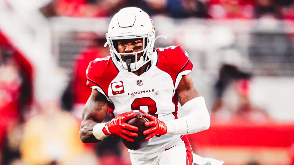 Budda Baker Arizona Cardinals intense game action clutching football red white uniform NFL energy Wallpaper