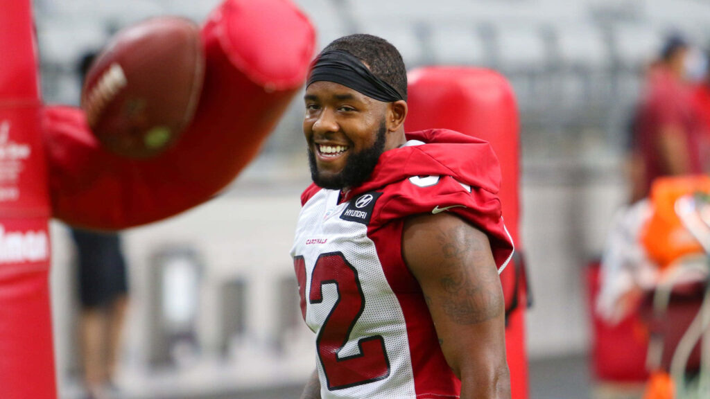 Budda Baker Arizona Cardinals training on field smiling in red white uniform vibrant practice Wallpaper