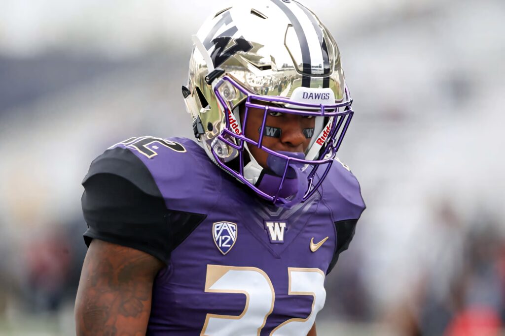 Budda Baker football wallpaper purple uniform number 32 gold helmet intense athletic game background