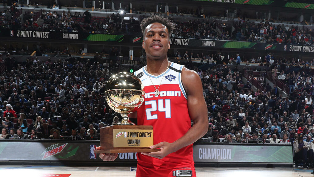 Buddy Hield in red jersey holding 3-Point Contest Champion trophy on basketball court celebrating victory Wallpaper