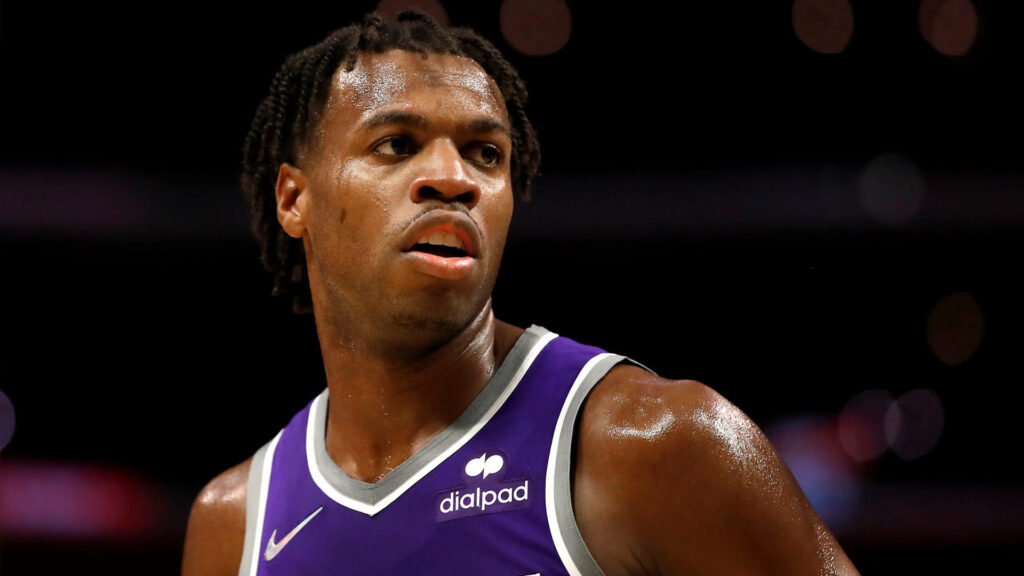 Buddy Hield in purple jersey focused intensely during basketball game action wallpaper background