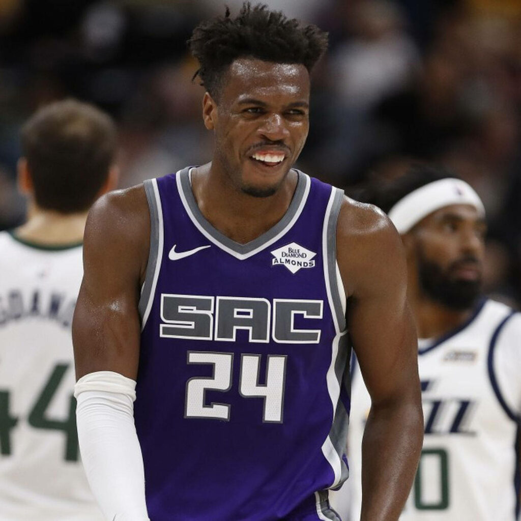 Buddy Hield Sacramento Kings laughing on court vibrant jersey energetic basketball wallpaper background