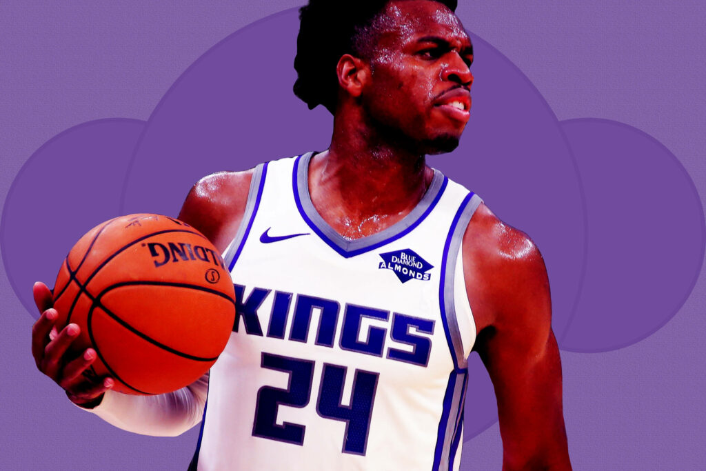 Buddy Hield in Sacramento Kings uniform holding basketball energetic purple NBA wallpaper background