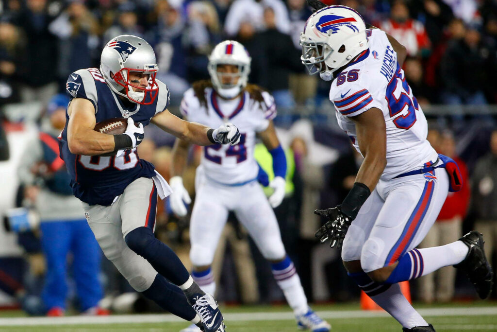 Buffalo Bills defenders chase New England Patriots player during intense NFL game action wallpaper