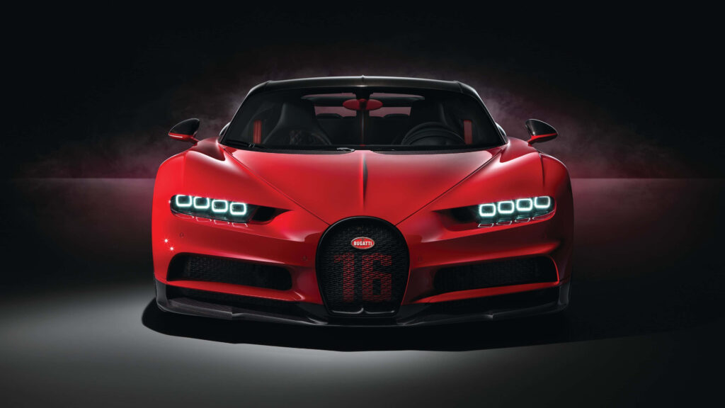 Bold red Bugatti wallpaper with powerful grille and LED headlights on dark dramatic background