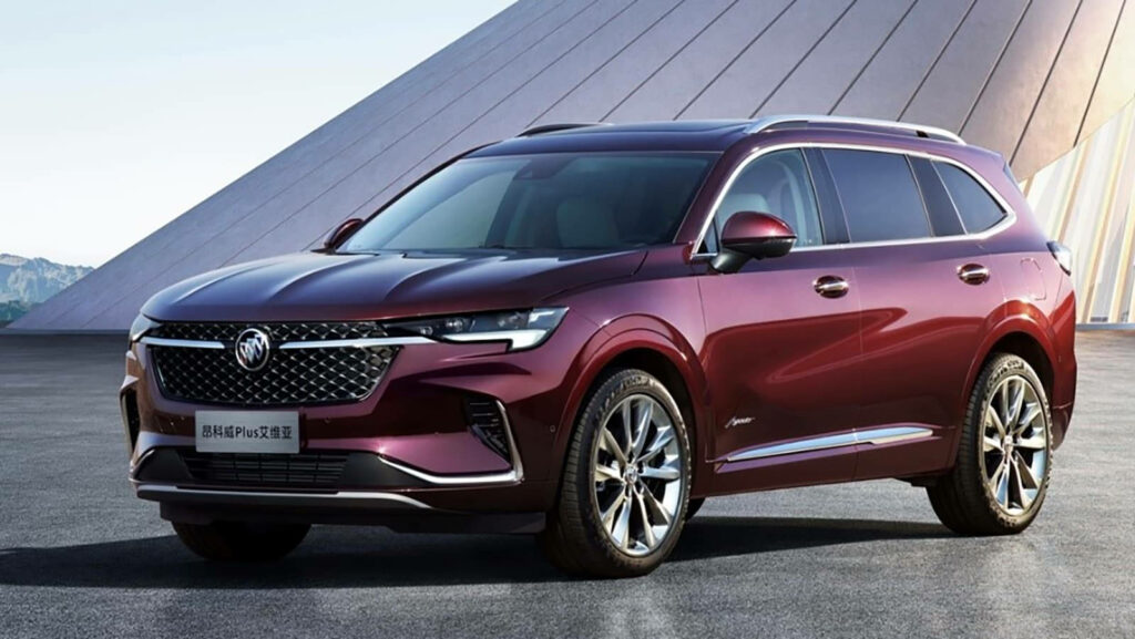Maroon Buick Envision SUV with bold lines and sleek grille against modern architecture background Wallpaper