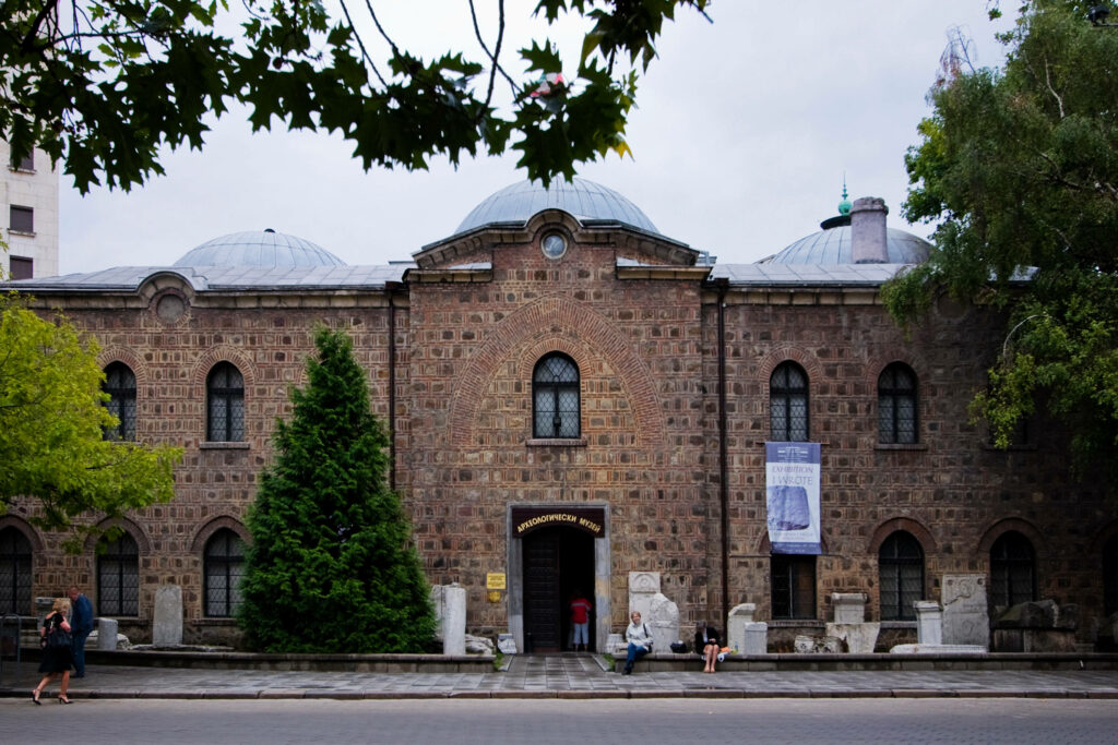 Historic Bulgarian Archaeological Museum stone facade with arched windows and green surroundings Wallpaper