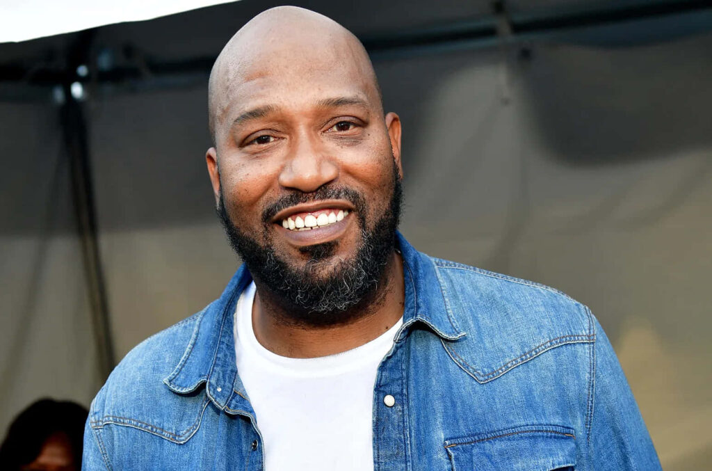 Bun B rapper outdoors wearing denim jacket smiling with blurred urban background wallpaper