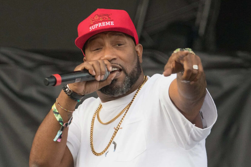 Bun B performing live wearing red Supreme cap gold chains white shirt energetic concert wallpaper