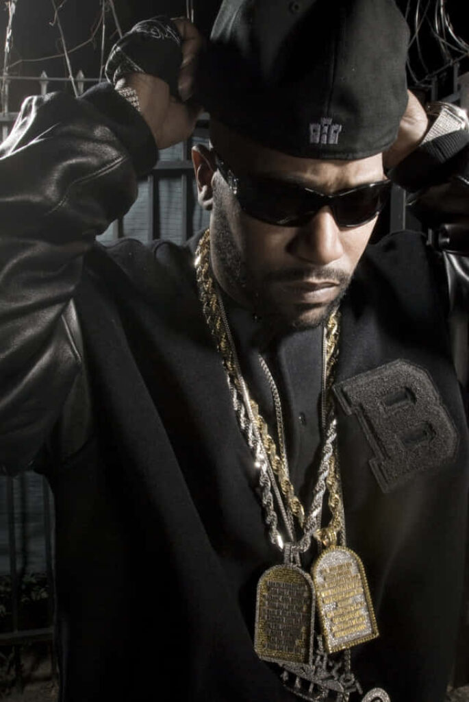 Bun B rapper in black cap sunglasses gold chains moody urban streetwear wallpaper background