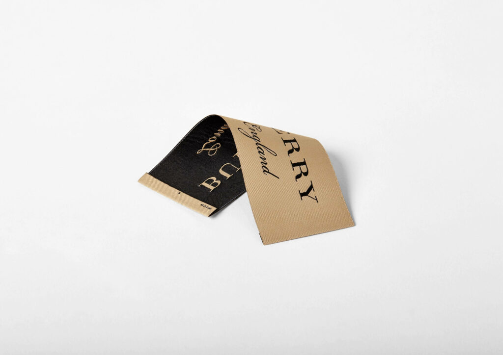 Burberry's Signature: Exquisite Cloth Label Tag on a Minimalistic White Canvas Wallpaper