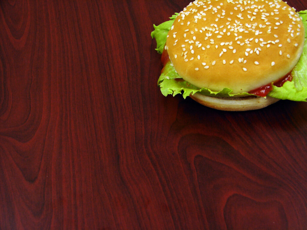Burger King sesame seed bun sandwich with fresh lettuce and ketchup on dark wooden background Wallpaper