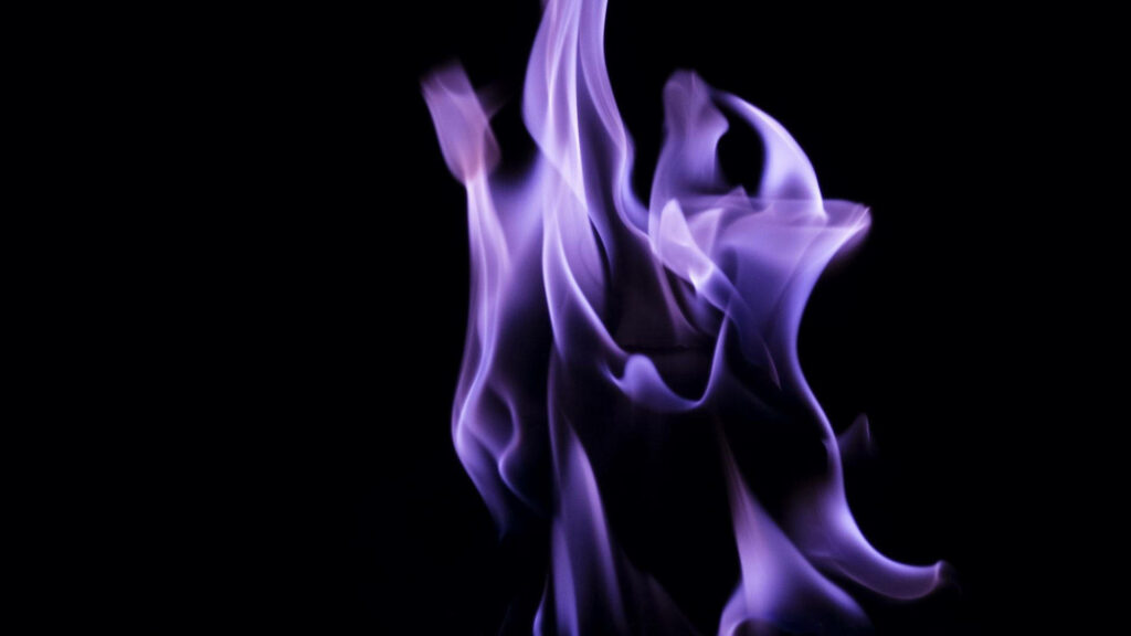 Infernal Beauty: Mesmerizing Black and Purple Flames Dance Against a Gothic Canvas Wallpaper