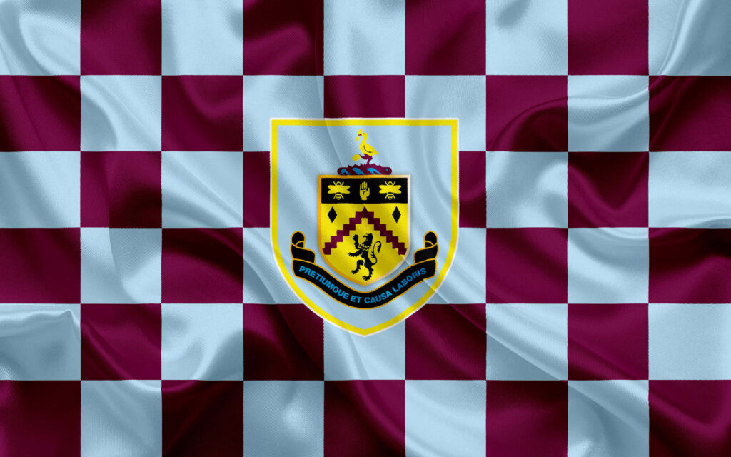 Burnley FC crest on claret and blue checkered silky background showcasing team colors Wallpaper
