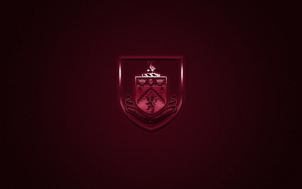 Burnley FC crest on textured dark maroon background featuring lion castle motifs wallpaper