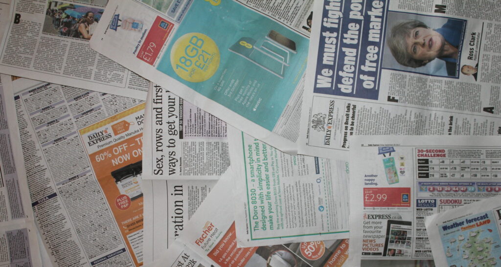 Overhead collage of Daily Express pages September 29 2017 with articles ads lottery and Theresa May photo Wallpaper