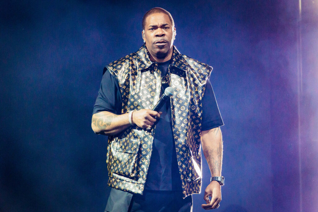Busta Rhymes performing live hip-hop on stage with dynamic lighting and bold fashion style Wallpaper